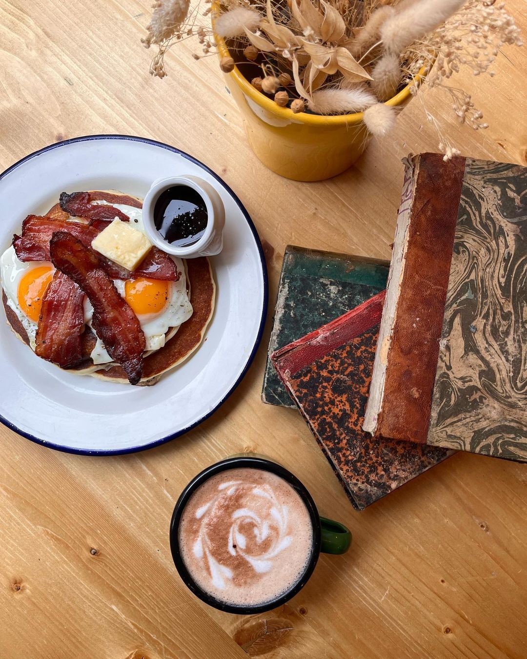 photo de pancakes avec une tasse de café et des livres